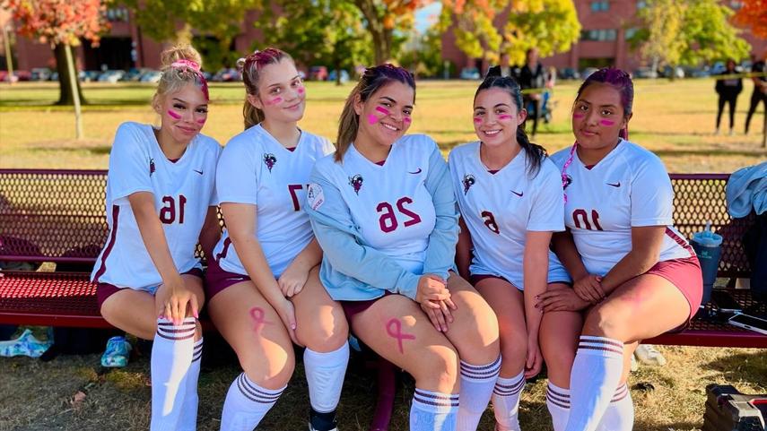 women's soccer players smiling on bench